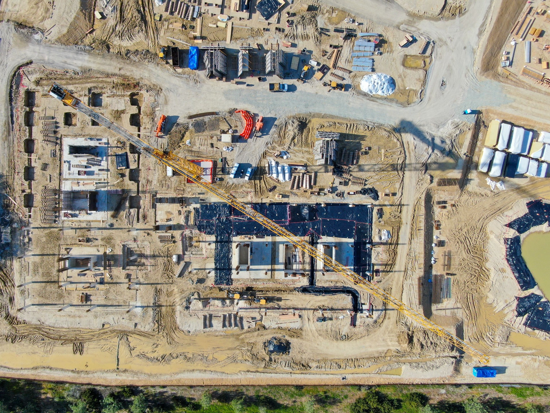 Aerial view of new construction site with crane and building materials